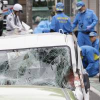 Police inspect a pickup truck that hit elementary school children on a street in Yokohama on Friday. | KYODO