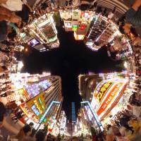 The neon-lit buildings of Tokyo\'s Shinjuku Ward get ringed by pedestrians in this head-spinning Sept. 25 image. | YOSHIAKI MIURA