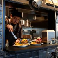 J.S. Burgers Cafe chef Yasuhito Fukui prepares Mr. and Mrs. burgers featuring U.S. presidential candidates Hillary Clinton and Donald Trump in Tokyo on Oct. 7. | REUTERS