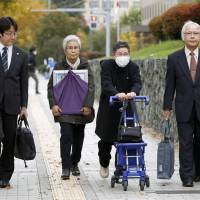 Relatives of a family devastated by a fatal car crash last year enter the Sapporo District Court on Monday. | KYODO