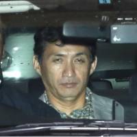 Keitaro Saga, who was arrested Tuesday in connection with the killing of his ex-girlfriend, leaves the Meguro Police Station in Tokyo in a police car Wednesday. | KYODO