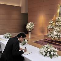 People write their names and messages of condolence in a special book opened at the Thai Embassy in Shinagawa Ward, Tokyo, on Friday following the death of Thai King Bhumibol Adulyadej. | YOSHIAKI MIURA