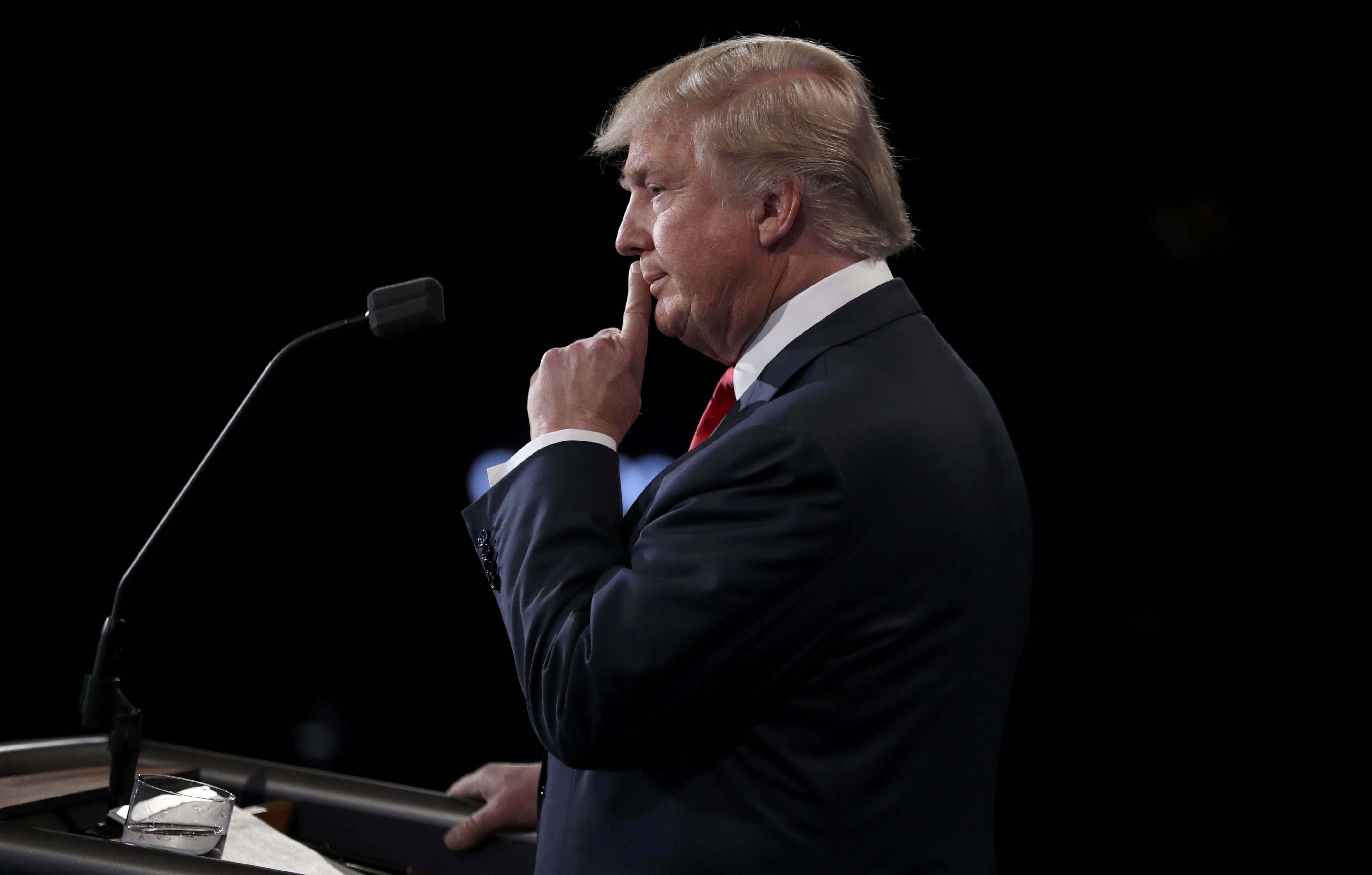 Donald Trump listens to rival Hillary Clinton during their presidential debate in Las Vegas on Wednesday. | REUTERS