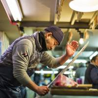 Slice of life: A worker at Tsukiji fish market carves up his catch in a scene from “Tsukiji Wonderland.” Tsukiji: Still a fish in troubled waters