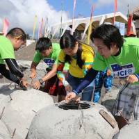 Volunteers prepare \"rosary beads\" fitted with solar cells to stimulate coral growth before the beads are dropped into the Albay Gulf in the Philippines. | JCI LEGAZPI