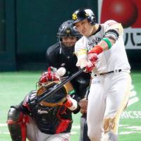The Hawks\' Seiichi Uchikawa hits a solo home run off Mariners starter Hideaki Wakui in the third inning during Game 1 of the first stage of the Pacific League Climax Series on Saturday. Fukuoka SoftBank defeated Chiba Lotte 4-3. | KYODO