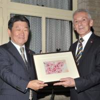 Bulgaria\'s Ambassador Georgi Vassilev (right) receives a sakura  print from Toshimitsu Motegi, chairman of Japan-Bulgaria Parliamentary Friendship League and Liberal Democratic Party Policy Research Council, during a farewell reception for Vassilev at the ambassador\'s residence in Tokyo on Sept. 29. | YOSHIAKI MIURA