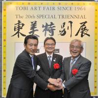 Tokyo Art Dealers\' Association Chairman and Tokyo Art Club Co. Ltd. Vice President Jun Nakamura (left) welcomes Commissioner for Cultural Affairs Ryohei Miyata (center) and former Commissioner for Cultural Affairs Masanori Aoyagi to the opening reception of the 20th TOBI Art Fair Special Triennial at the Tokyo Art Club in Tokyo\'s Minato Ward on Oct. 13. | YOSHIAKI MIURA