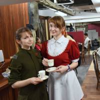 Cafe manager Nastyan (left) tends to customers on the opening day Monday of Itacafe, a Russian-themed maid cafe serving Russian cuisine in Shinjuku Ward, Tokyo. Dressed in Red Army-style tunic and tight hot pants, Nastyan said she used crowdfunding to raise &#165;3.2 million for the project. | SATOKO KAWASAKI