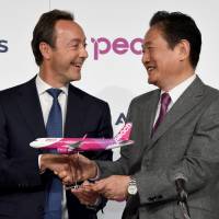 Airbus Chief Operating Officer Fabrice Bregier (left) shakes hands with Peach Aviation CEO Shinichi Inoue at a joint news conference in Tokyo on Friday. | AFP-JIJI