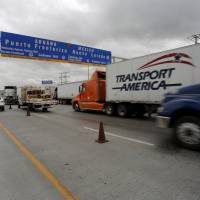 Trucks wait for border customs control to cross into the U.S. at the World Trade Bridge in Nuevo Laredo, Mexico, Wednesday. | REUTERS