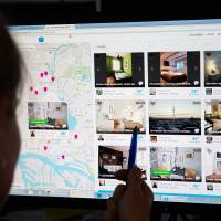 A woman browses places to stay on the Airbnb website.  | CHRISTIAN CHARISIUS/PICTURE-ALLIANCE/DPA/AP IMAGES