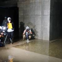 Reporters investigate ground water in the basement of the new Toyosu produce market in September. | MAGDALENA OSUMI