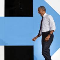 U.S. President Barack Obama reacts to seeing supporters as he walks on stage at PNC Music Pavilion in Charlotte, North Carolina, on Friday during a campaign rally for Democratic presidential candidate Hillary Clinton. | AP