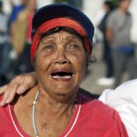 A woman weeps as she walks past the monument in honor of independence hero Jose Marti while paying her respects to Fidel Castro in Revolution Plaza in Havana Monday. Havana\'s Revolution Plaza is the site of a two-day tribute to Castro, who died late Friday. | AP