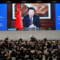 Attendees listen to a speech by Chinese President Xi Jinping shown on a screen during the opening ceremony of the third annual World Internet Conference in Wuzhen, China, on Wednesday. | REUTERS