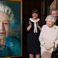 Britain\'s Queen Elizabeth II acknowledges applause as (from left) Arlene Foster, first minister of Northern Ireland; Martin McGuinness, deputy first minister of Northern Ireland; and Frances Fitzgerald, minister of justice and equality governor of Ireland, clap as the Queen unveils a portrait of herself by artist Colin Davidson during a Co-operation Ireland reception at Crosby Hall in London Tuesday. | JEFF SPICER / POOL PHOTO VIA AP