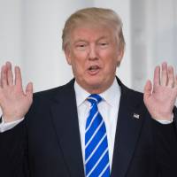 U.S. President-elect Donald Trump yells out to the media from the steps of the Trump National Golf Club clubhouse on Saturday in Bedminster, New Jersey. | AFP-JIJI
