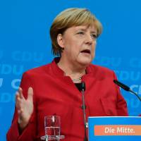 German Chancellor Angela Merkel addresses a news conference at the Christian Democratic Union party headquarters in Berlin on Sunday after earlier telling her party she will seek re-election next year. | AFP-JIJI