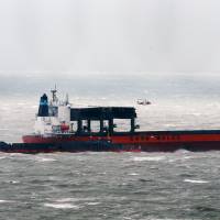 A coast guard helicopter attends the scene where some crew members are being removed from the cargo ship that is taking on water in the English Channel, as Storm Angus, the year\'s first big winter storm in Britain, lashes England\'s south coast Sunday. | GARETH FULLER / PA VIA AP