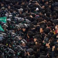 Protesters stand before police during an anti-government rally in the Gwanghwamun area of central Seoul on Saturday demanding the resignation of scandal-hit President Park Geun-hye. | AFP-JIJI