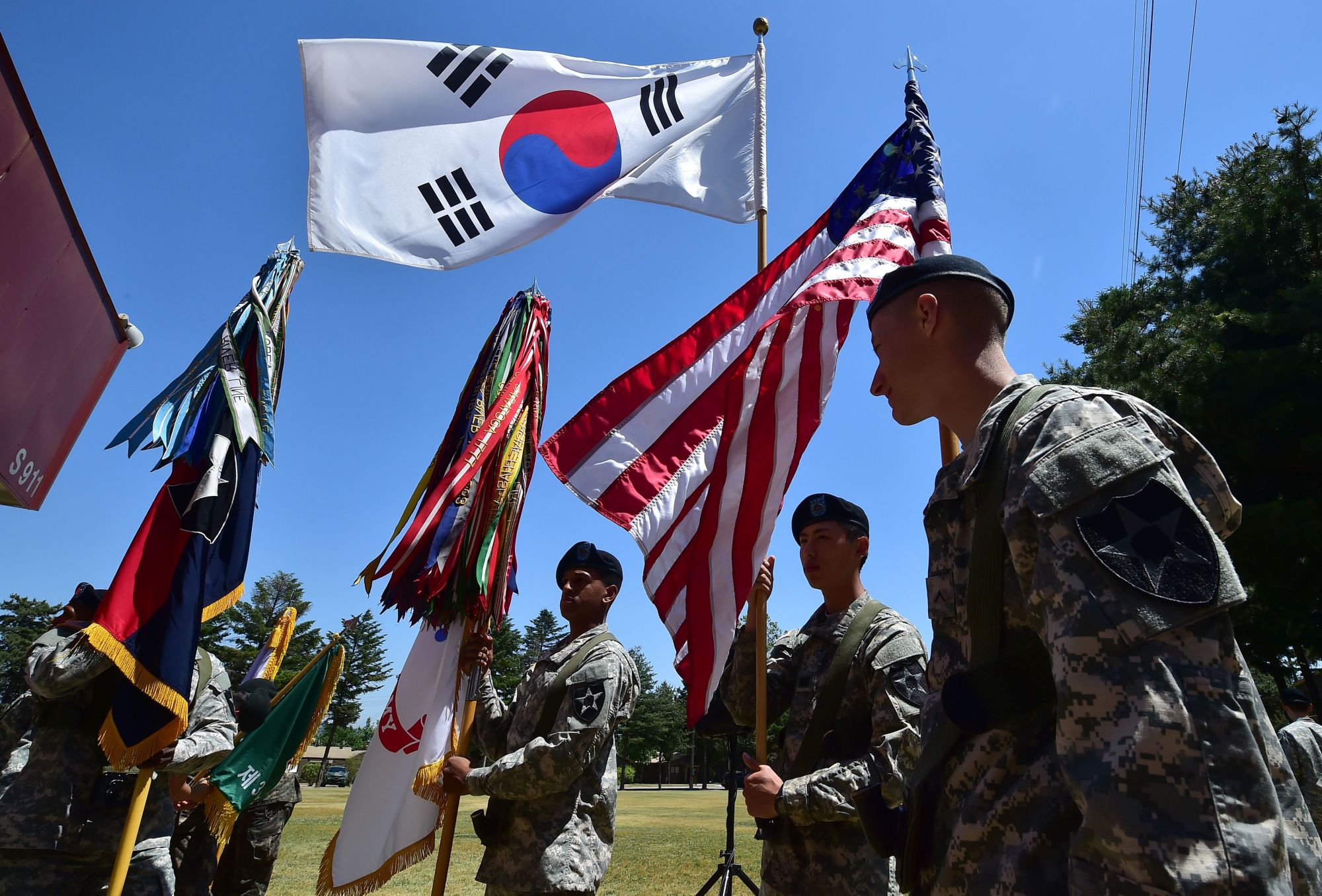 American soldiers hold the South Korean and U.S. flags before a joint ceremony at a U.S. Army base in Uijeongbu, just north of Seoul, in June 2015. | AFP-JIJI