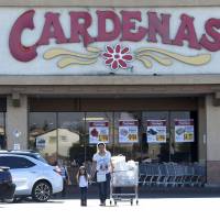 Customers exit Cardenas supermarket, where an advance polling station for the U.S. presidential election was allowed to remain open late on Friday, in an east side neighborhood of Las Vegas Tuesday. Republican Donald Trump sued the registrar of voters in Clark County, Nevada, over the polling place. | REUTERS