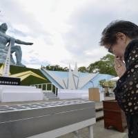 A woman prays at Nagasaki Peace Park on Aug. 9 this year, on the 71st anniversary of the 1945 atomic bombing on the city of Nagasaki. | KYODO