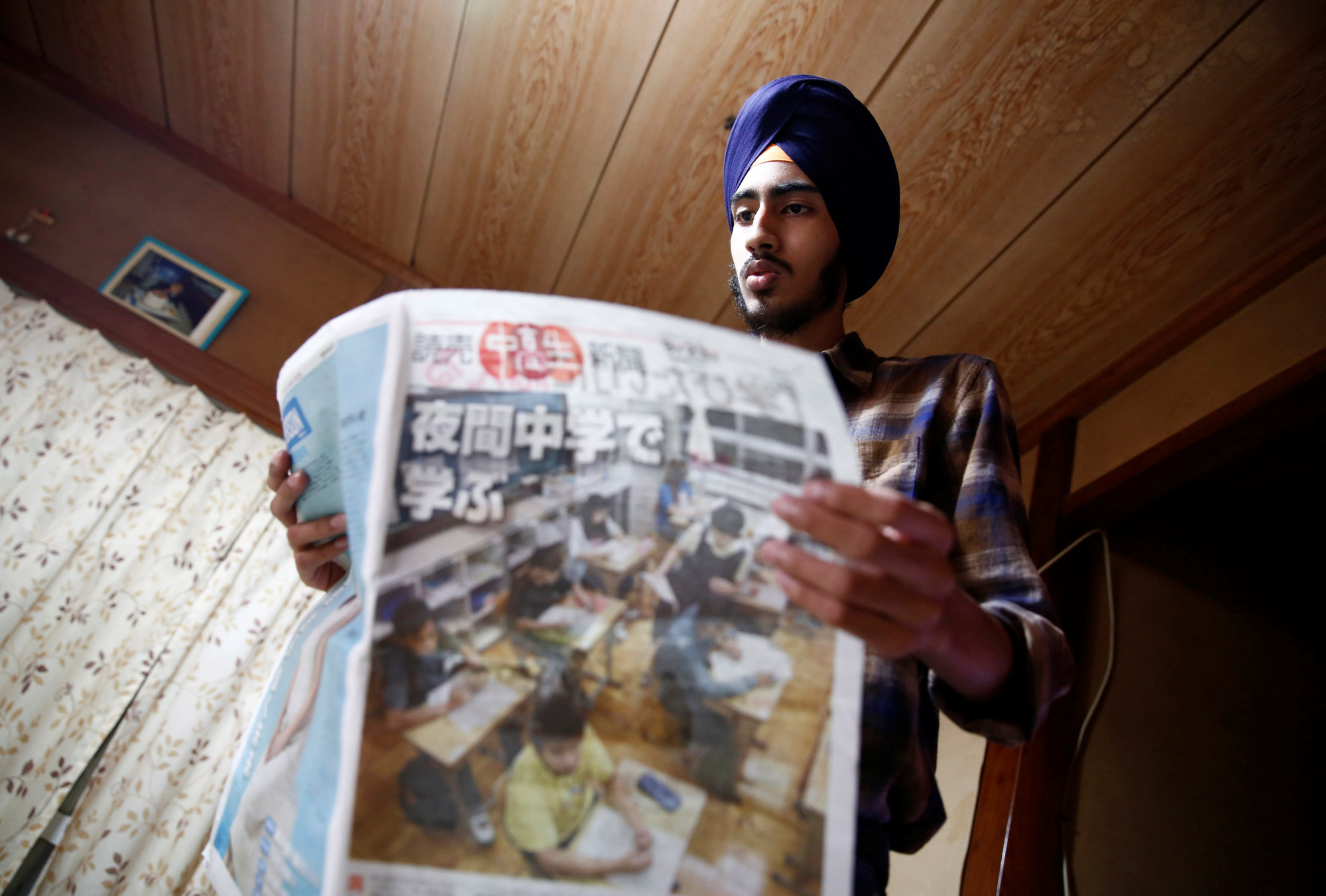 Gursewak Singh holds a Japanese newspaper at his home in Matsudo, Chiba Prefecture, on Sept. 25. | REUTERS