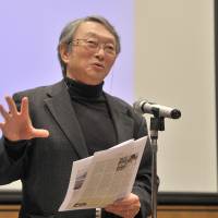 Kensaku Yoshida, a professor at Sophia University, comments on students’ work during the All Japan Junior and Senior High School English Newspaper Contest in Tokyo last Sunday. | YOSHIAKI MIURA