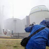 Workers spray water during a disaster drill Sunday at the Tomari nuclear power plant in Hokkaido. | KYODO