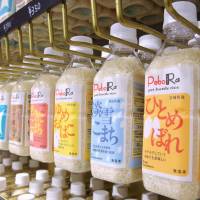 Plastic bottles containing uncooked rice are displayed at a store in Hachinohe, Aomori Prefecture, on Nov. 1. | KYODO