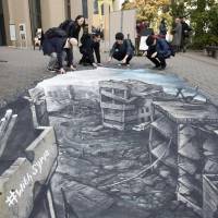 Passers-by view a 3-D artwork illustrating the Syrian city of Aleppo displayed at Meiji University Thursday. 3-D optical illusion artwork in Tokyo familiarizes Syria problem