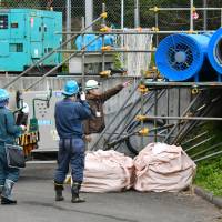 Police Wednesday investigate the area near the entrance of an industrial water tunnel in Kudamatsu, Yamaguchi Prefecture, where nine workers were hospitalized because of carbon monoxide poisoning. | KYODO