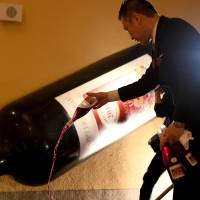 A sommelier tops up the bath straight from the bottle. | TOSHIFUMI KITAMURA / AFP-JIJI