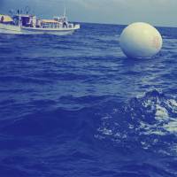 A documentary photograph of “The Play: Voyage — Happening in an Egg,” taken on Aug. 1, 1968, off the southern coast of Kushimoto, Wakayama Prefecture. A play on the idea of performance art