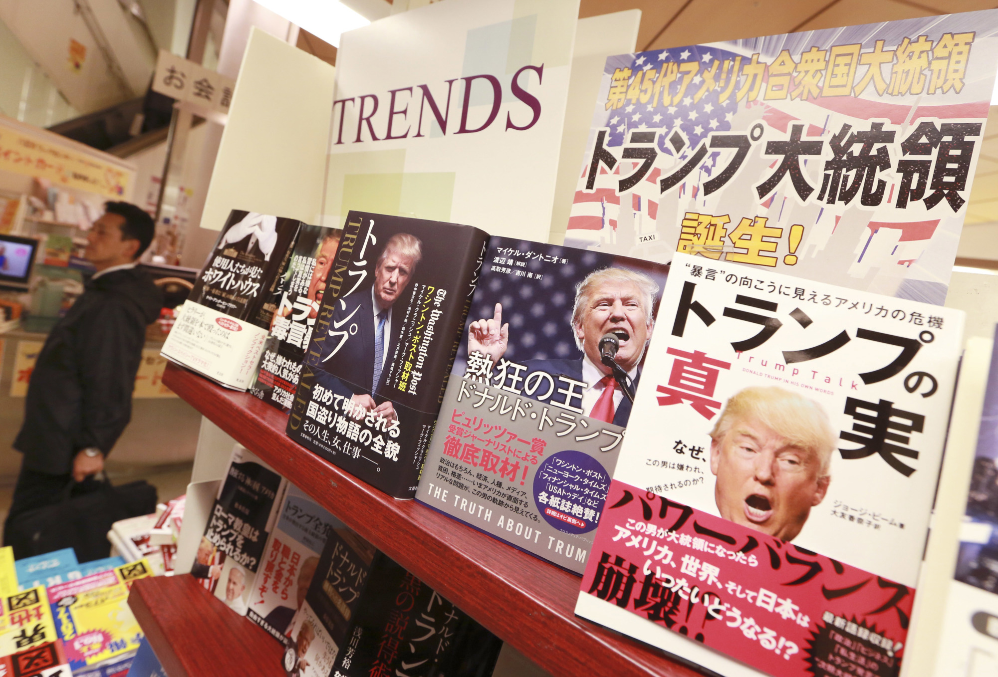 Fifteen books in Japanese about U.S. President-elect Donald Trump are displayed on a special shelf set up at the Yaesu Book Center in Tokyo in the wake of the Republican nominee's surprise triumph last week. | AP