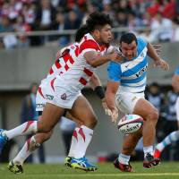 Argentina\'s Agustin Creevy (right) reaches for the ball as he is grabbed by Japan\'s Shota Horie in Saturday\'s test match at Prince Chichibu Memorial Rugby Ground. | REUTERS