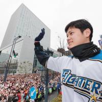 Hokkaido Nippon Ham\'s Shohei Otani waves to fans during a victory parade in Sapporo for the Japan Series- and Pacific League-champion Fighters. | KYODO