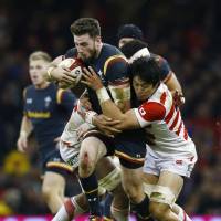 Wales\' Alex Cuthbert (left) tries to break through a tackle by Japan\'s Kyosuke Kajikawa during their game at Principality Stadium in Cardiff, Wales, on Saturday. | REUTERS