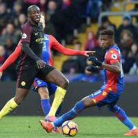 Manchester City\'s Yaya Toure (left) passes the ball as Crystal Palace\'s Wilfried Zaha tries to close him down during their game in London on Saturday. City won 2-1. | AFP-JIJI