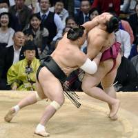 Harumafuji (left) grapples with Endo on Thursday at the Kyushu Grand Sumo Tournament in Fukuoka. Harumafuji won, improving to 4-1 at the 15-day tournament. | KYODO