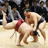 Yokozuna Kakuryu defeats third-ranked maegashira Endo at the Kyushu Grand Sumo Tournament on Saturday. Kakuryu improved to 7-0. | KYODO