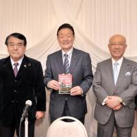 House of Councilors member Yukihisa Fujita (center) holds a copy of a revised edition of a book he first translated 26 years ago, \"Japan\'s Decisive Decade\" (by Basil Entwistle, a former representative of Moral Rearmament in Japan) during a commemorative reception at Le Port Kojimachi on Oct. 31. Fujita was joined by (from left) former Prime Minister Yukio Hatoyama; Japan Research Institute Chairman Jitsuro Terashima; Senior Advisor of the Development Bank of Japan Toru Hashimoto; and Chairman of International Initiatives of Change (IC) Japan Association Hironori Yano. | YOSHIAKI MIURA
