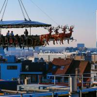 Guests dine at the Santa in the Sky restaurant, held up by a crane, above Brussels on Friday. As part as Christmas festivities in the Belgian capital, the restaurant has been decorated like St. Nick\'s sleigh. | REUTERS