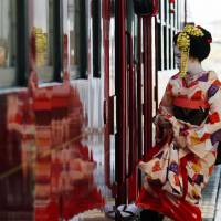 A maiko (apprentice geisha) boards a Nagaragawa Railway Nagara train at Mino-Ota Station in Minokamo, Gifu Prefecture, on Tuesday. The train, featuring maiko performances, will run on six days between Jan. 11 and Feb. 14, 2017. Local dishes will also be served. | KYODO