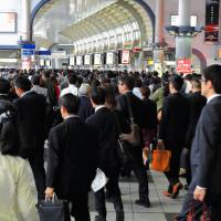Commuters walk at Shinagawa Station in Tokyo. | ISTOCK
