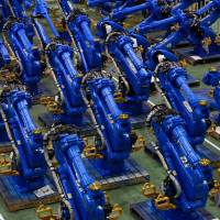 Yaskawa Electric Corp.\'s Motoman robots await shipment at the company\'s factory in Kitakyushu in July 2015. | BLOOMBERG