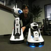 Cerevo Inc. CEO Takuma Iwasa poses with the new Tipron home projector robot in Tokyo on Friday. | KAZUAKI NAGATA