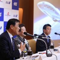 Hideo Sawada (left), chairman and CEO of H.I.S. Co., speaks as Shuji Ogawa (center), CEO of PD Aerospace Ltd., and Shinya Katanozaka, president and CEO of ANA Holdings Inc., look on during a news conference in Tokyo on Thursday. | BLOOMBERG